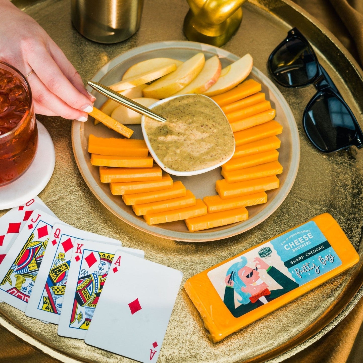 Sliced Pretty Boy Cheddar cheese on a plate with apples and dip