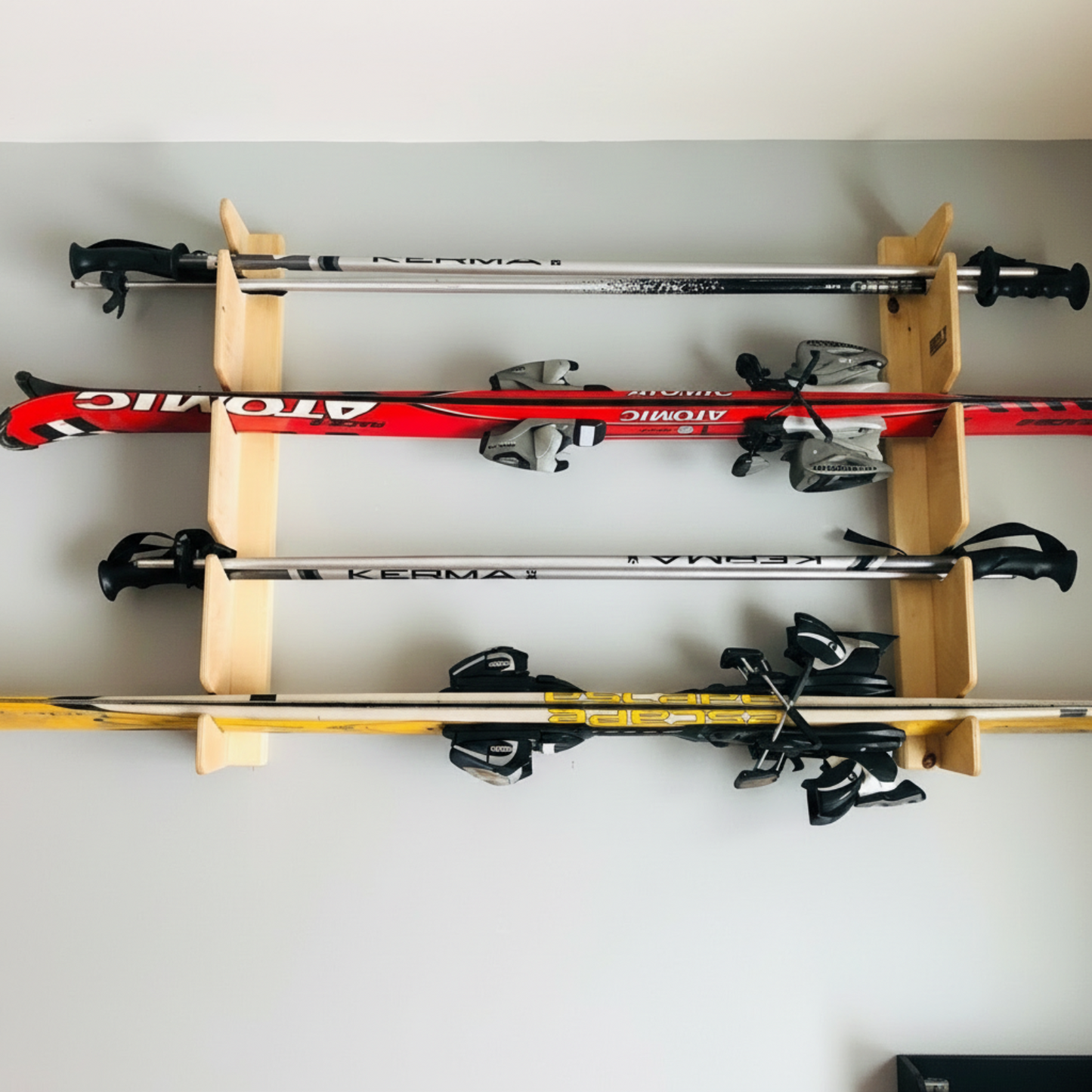Flush-mounted ski rack holding multiple pairs of snow skis and poles, neatly organized.