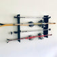 Flush-mounted ski rack in black finish holding multiple pairs of snow skis and poles, neatly organized on a wall.