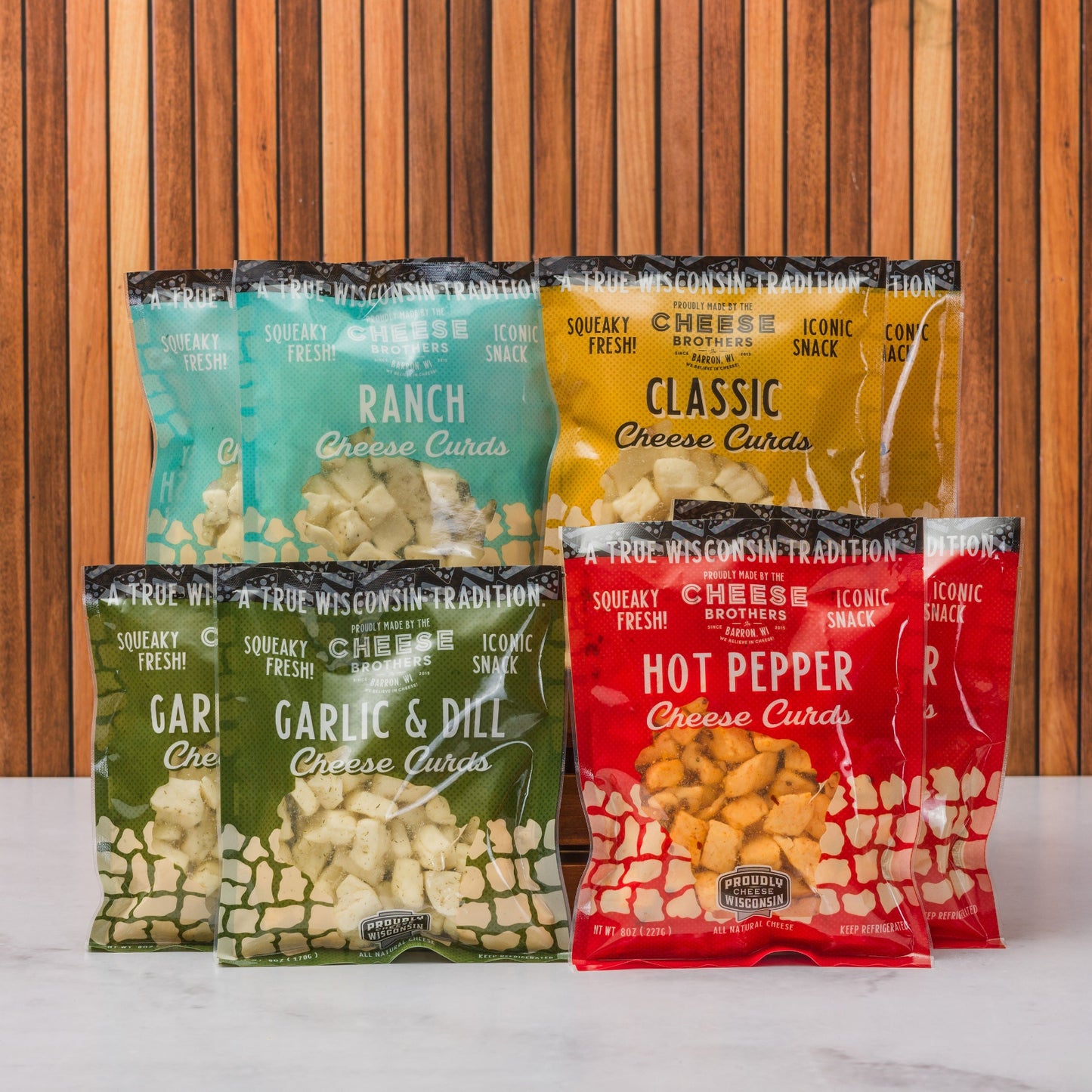 assorted packs of wisconsin cheese curds with wooden background