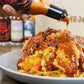 Pepper Joe's Carolina Reaper Hot Sauce - the reaper hot sauce pouring on a plate of fries