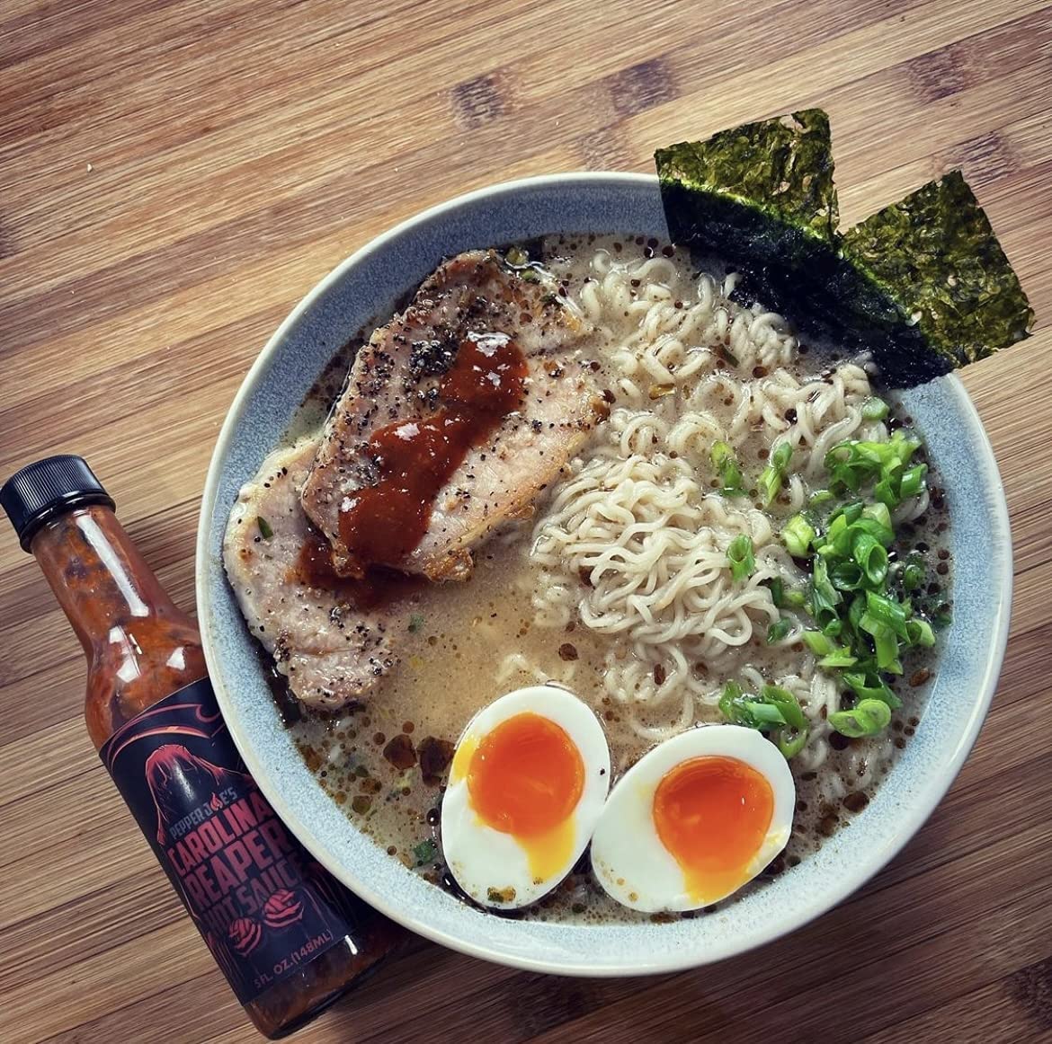 Pepper Joe's Carolina Reaper Sauce - ramen bowl with noodles and eggs with Carolina Reaper spicy hot sauce drizzled on top