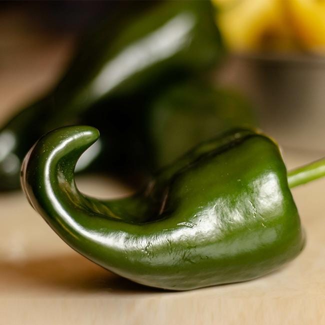 Pepper Joe's Chilli Relleno pepper - Chili relleno pepper with curled tail on wooden table