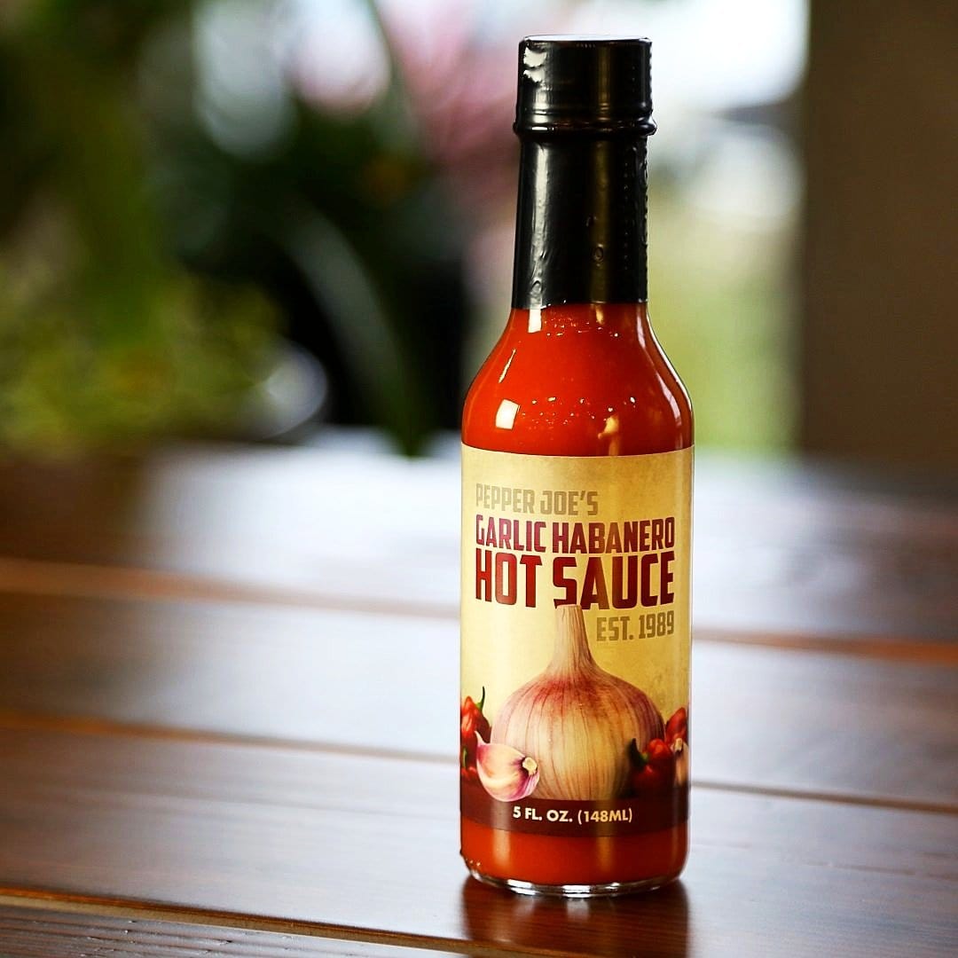 Pepper Joe's Gourmet Garlic Habanero Hot Sauce - Habanero pepper sauce - hot sauce on wooden table
