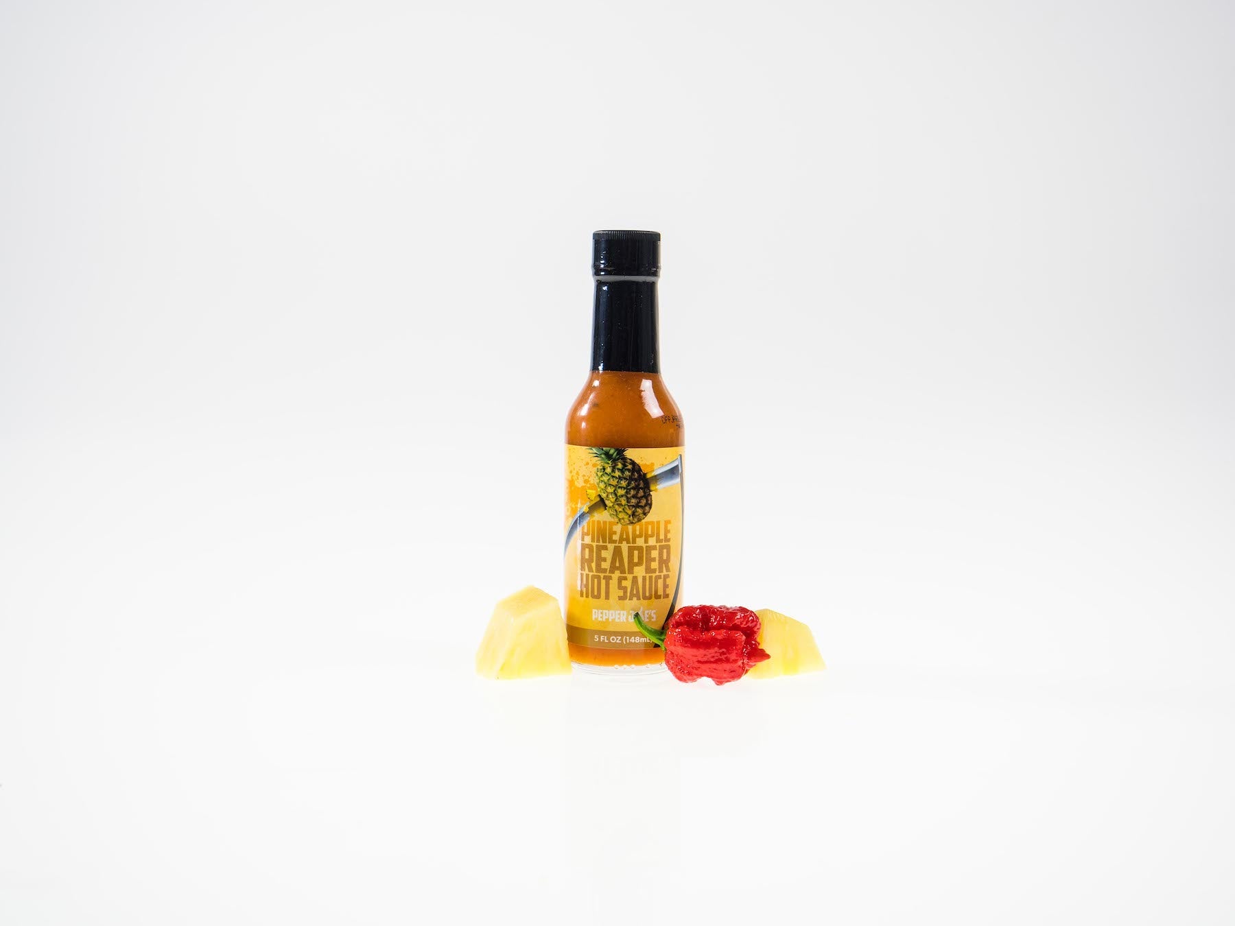Pepper Joe's Carolina Reaper Hottest Hot Sauce gift set - Pineapple Reaper hot sauce bottle with pineapple chunks around