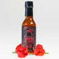 Pepper Joes Carolina Reaper Hot Sauce bottle with carolina reaper peppers surrounding it on white background