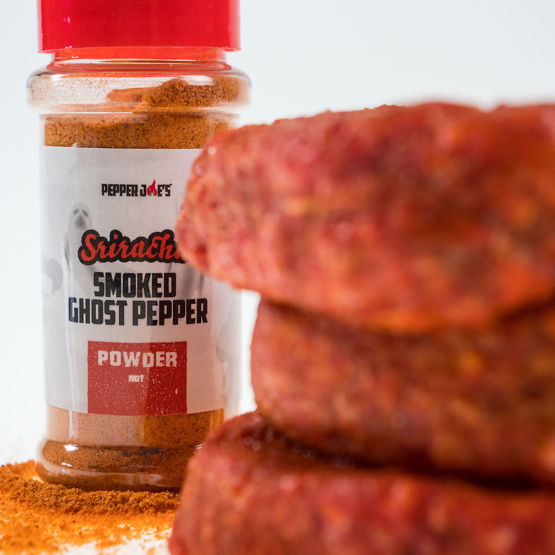 Sriracha Smoked Ghost Pepper Seasoning Spice jar next to raw meat to use seasoning and marinade