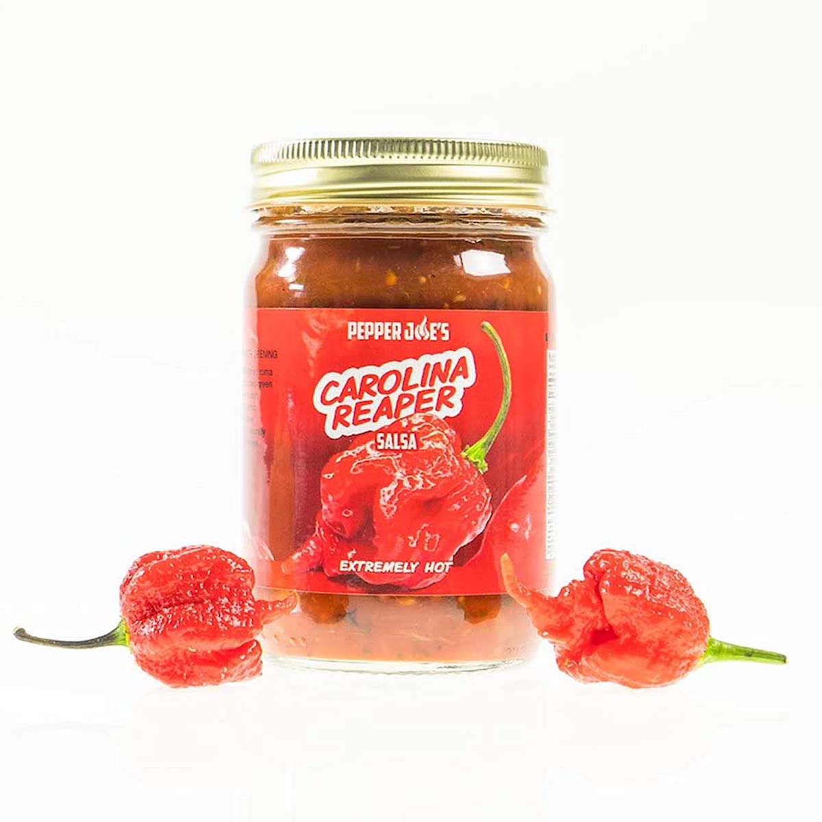 Pepper Joe's spicy Carolina Reaper salsa with carolina reaper peppers around jar on white background